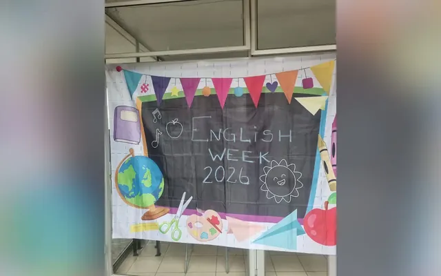 Telón pintado a mano con la leyenda English Week 2026, colgado en un pasillo del colegio